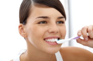 Image of pretty female brushing her teeth in the morning